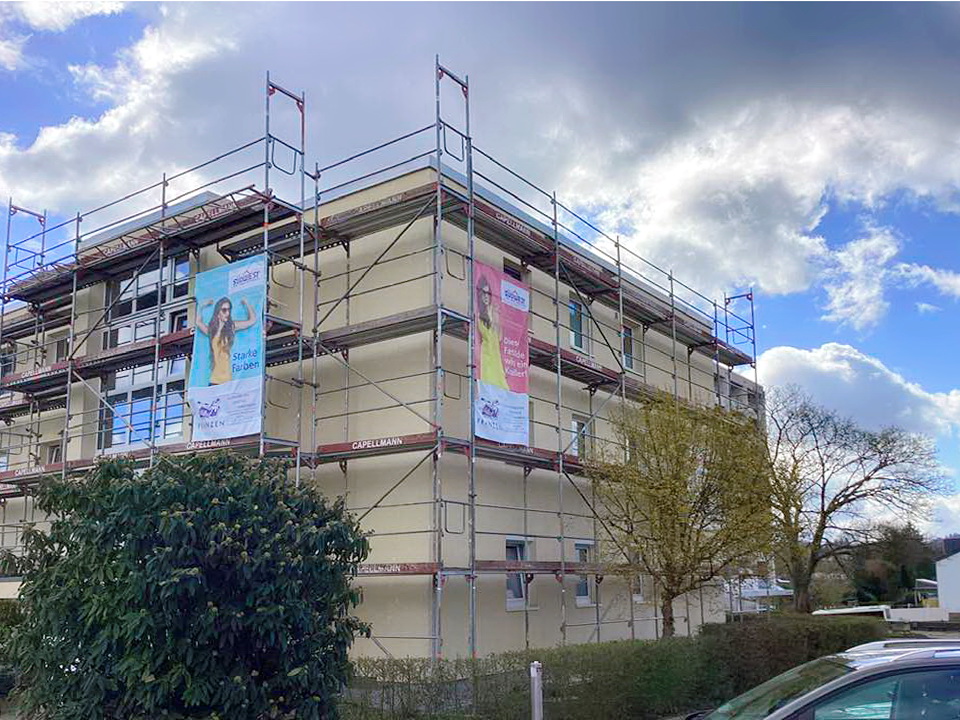 Eingerüstete Fassade eines Mehrfamilienhauses während der Malerarbeiten